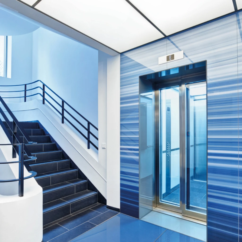 Treppenhaus und Aufzüge mit blauem Glas im Stammhaus der WDR mediagroup