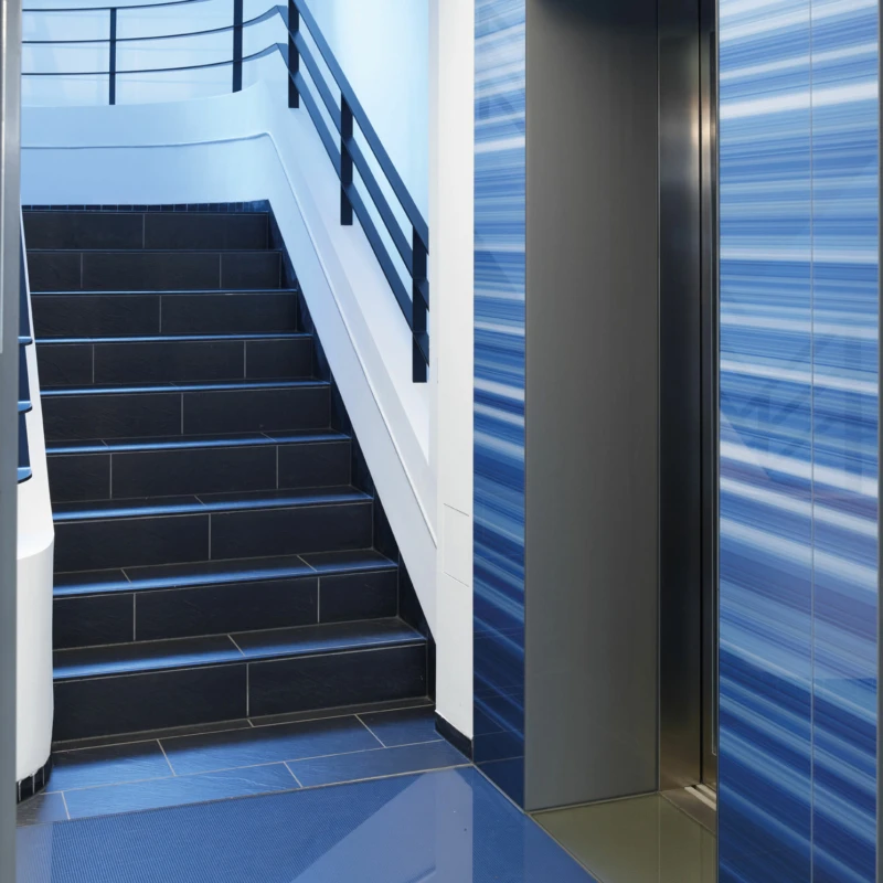 Treppenhaus und Aufzüge mit blauem Glas im Stammhaus der WDR mediagroup