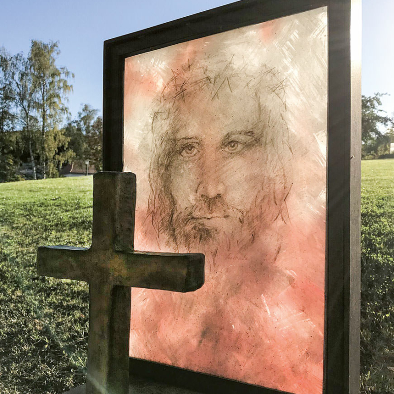 Auf Glas gemaltes Jesusgesicht mit davorstehendem Kreuz