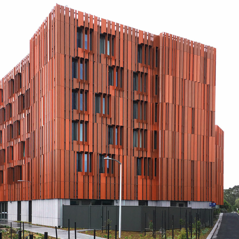 Südwestfassade des Studentenwohnheim Gillies Hall an der Monash University mit einer auffallenden Verkleidung aus rot-orangenen