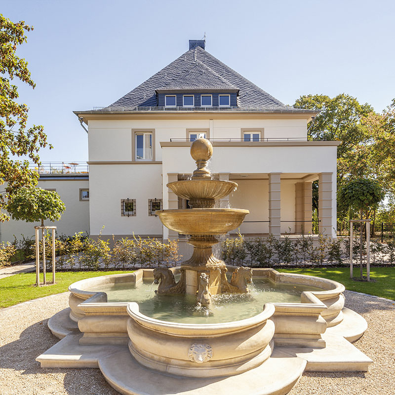 Außenansicht der denkmalgeschützten Villa in Waghäusel mit Blick auf den Brunnen