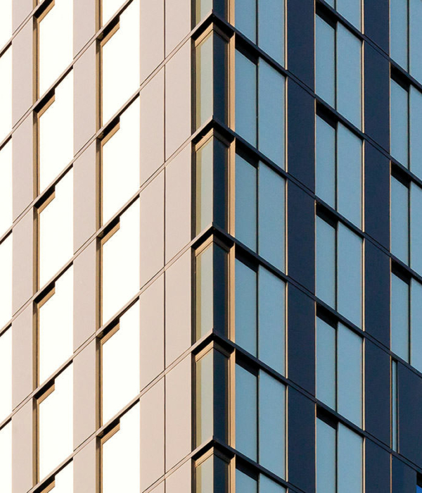 Fassade des Hotels QO mit bodentiefer Verglasung, Aluminiumelementen und beweglichen, goldenen Paneelen