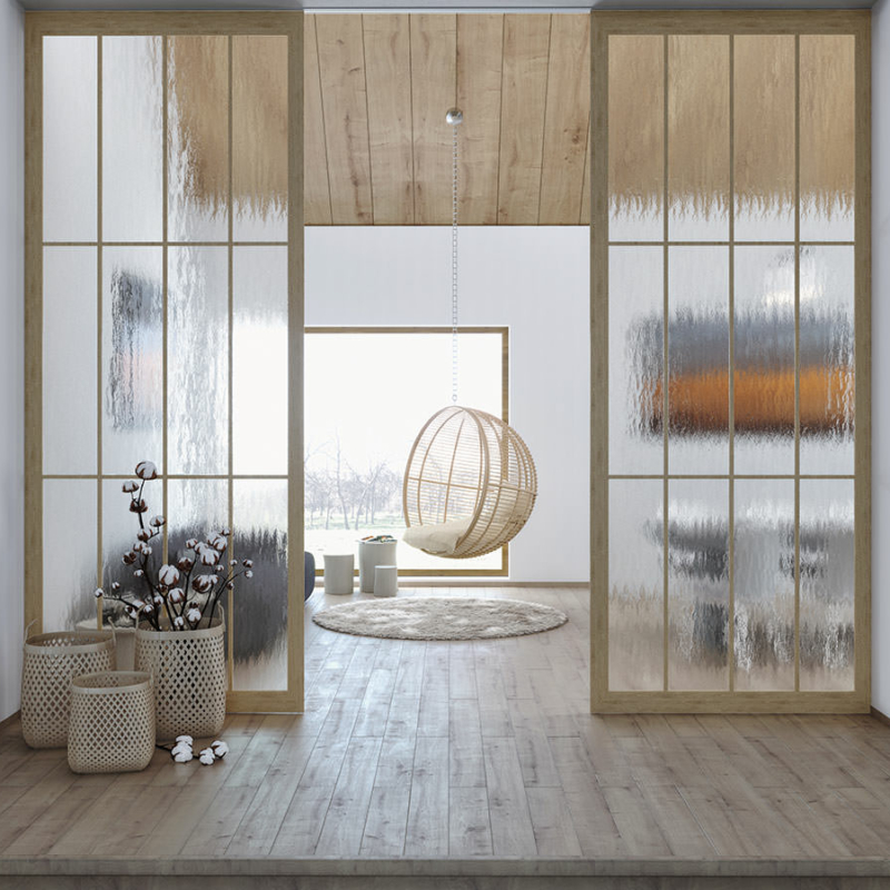 Raum mit hellem Holzboden und Holzdecke, unterteilt von zwei Glastüren mit strukturiertem Glas. Hinten ein Hängesessel vor einem bodentiefen Fenster.