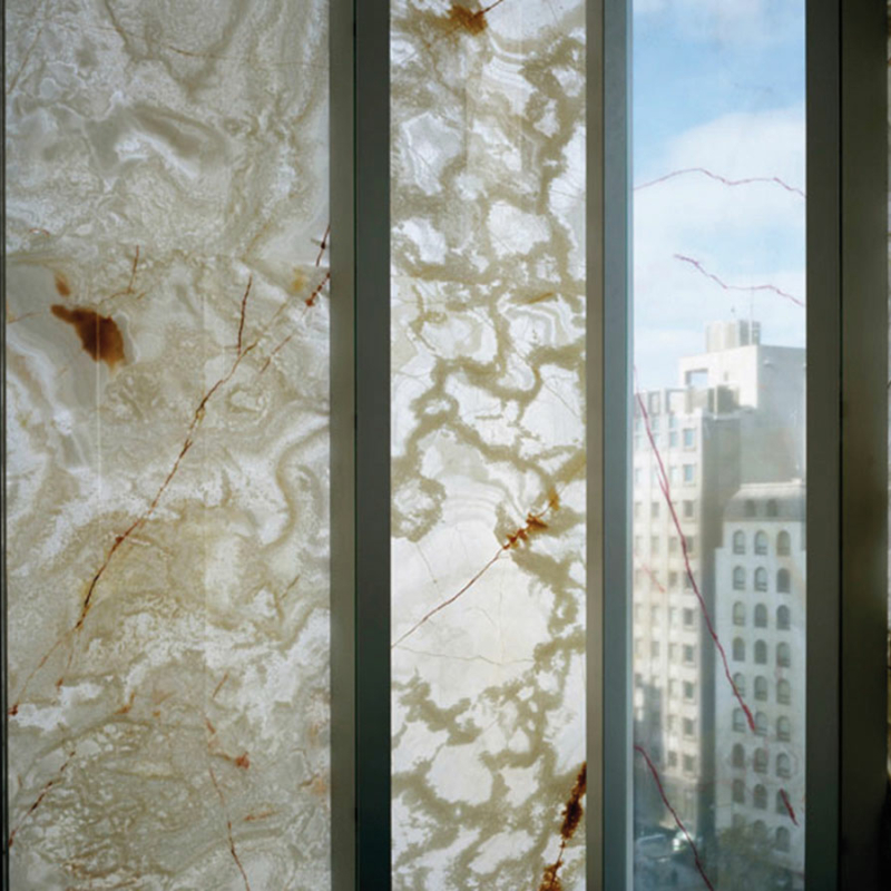Fensterscheiben, längs zwischen Rahmen angeordnet, die halbtransparente Steindekore in beigebrauntönen zeigen.