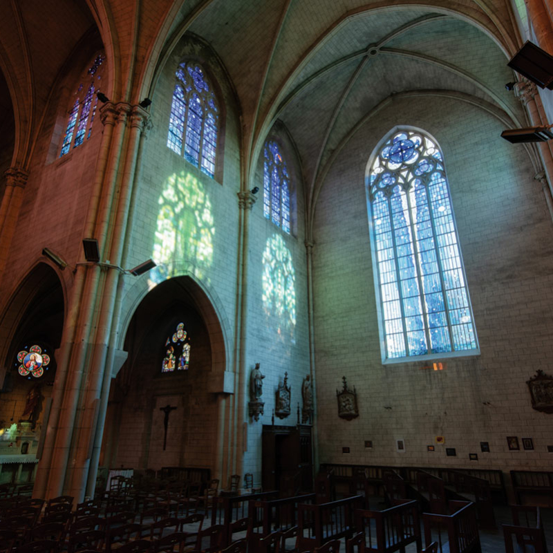 Teil eines Kircheninnenraumes mit Glasfenstern mit Gläsern in unterschiedlichen Blautönen