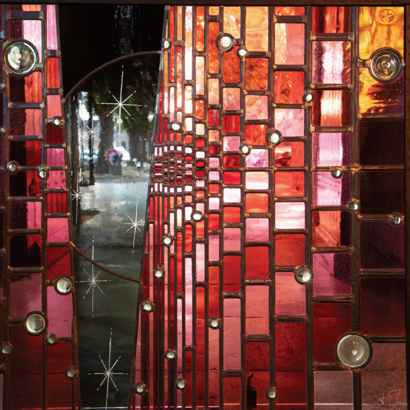 Teil eines Glasfensters aus vielen kleinen Gläsern in unterschiedlichen Rottönen, mit abstrahierten Motiven
