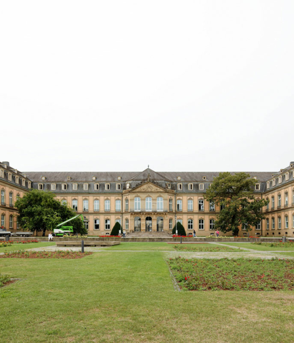 Frontalansicht des Neues Schlosses Stuttgart mit seinem zweistöckigen Hauptgebäude mit zwei rechtwinklig davon abgehenden Flügeln. Die klassische Lochfassade prägen rechteckige Fenster