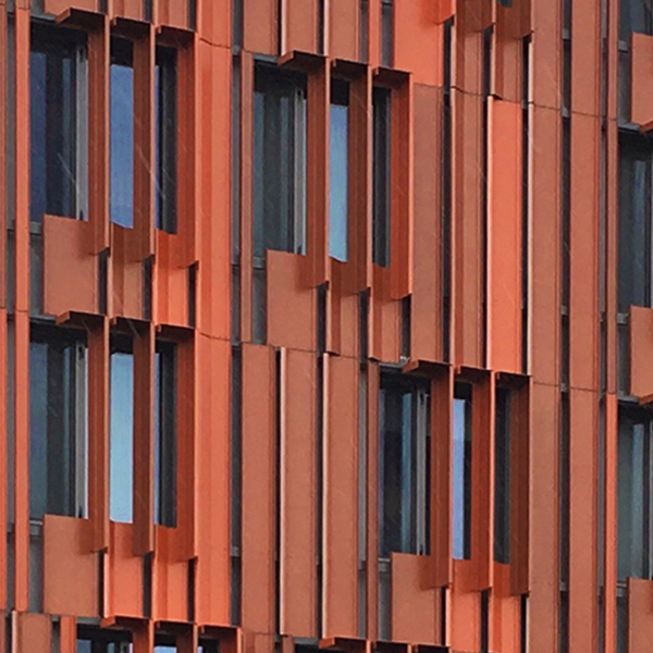 Das Studierendenwohnheim Gillies Hall an der Monash University mit der auffallenden Verkleidung aus rot-orangenen, vertikalen Blechlamellen war 2020 Australiens größtes zertifiziertes Passivhaus.