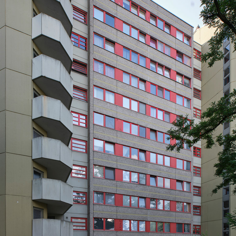 Blick auf ein elfgeschossiges Hochhaus mit orangefarbenen Fensterbändern