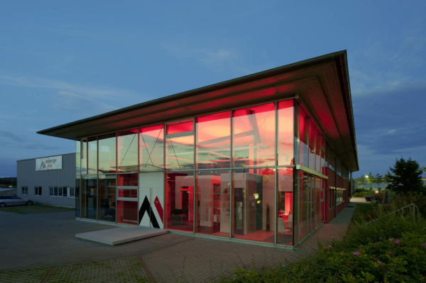 Außenansicht des Firmengebäudes von Amberger Glas in Amberg, moderner Produktionsstandort mit Unternehmensbeschriftung.