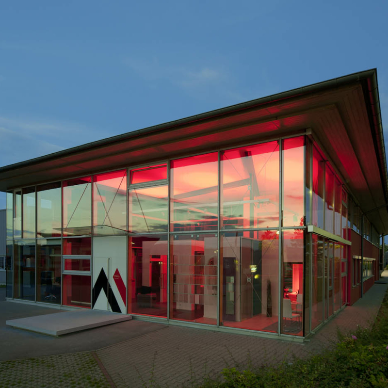 Außenansicht des Firmengebäudes von Amberger Glas in Amberg, moderner Produktionsstandort mit Unternehmensbeschriftung.